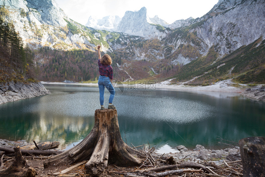女孩站在湖边的树桩上图片