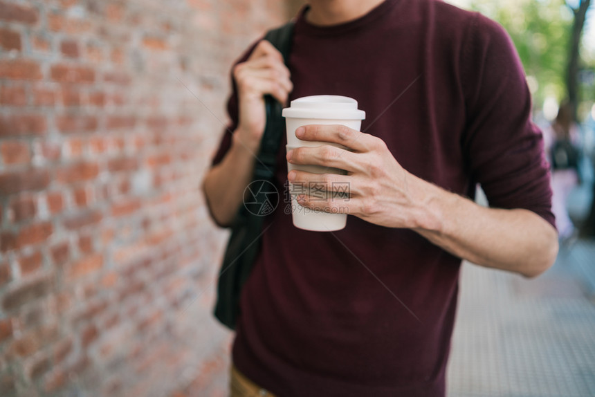 年轻人在街上行走和喝咖啡的肖像城市概念图片