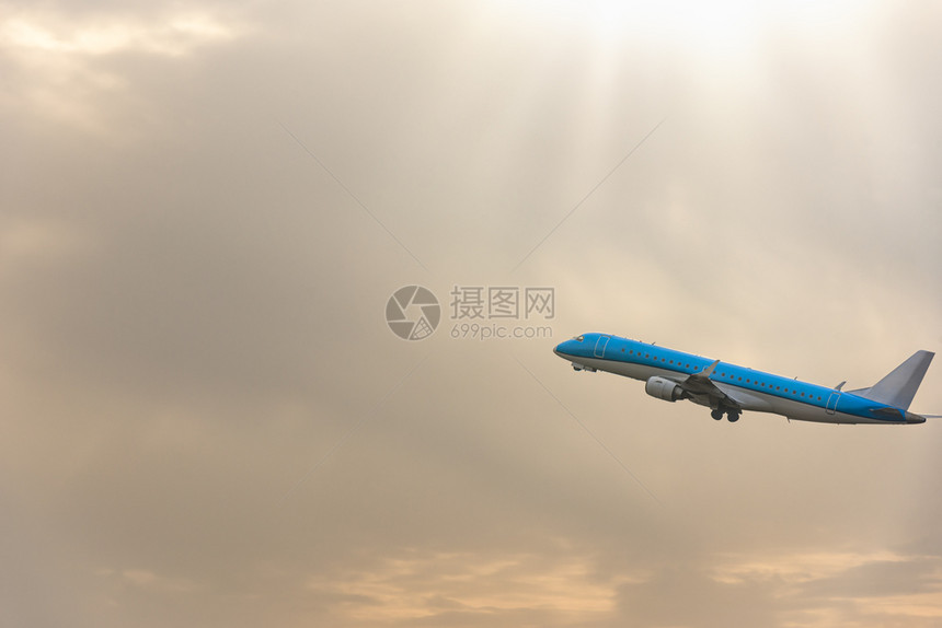 蓝色飞机在日出天空中飞行图片