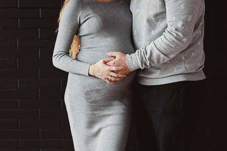 年轻夫妇期待婴儿抱肚子怀孕和人的概念图片