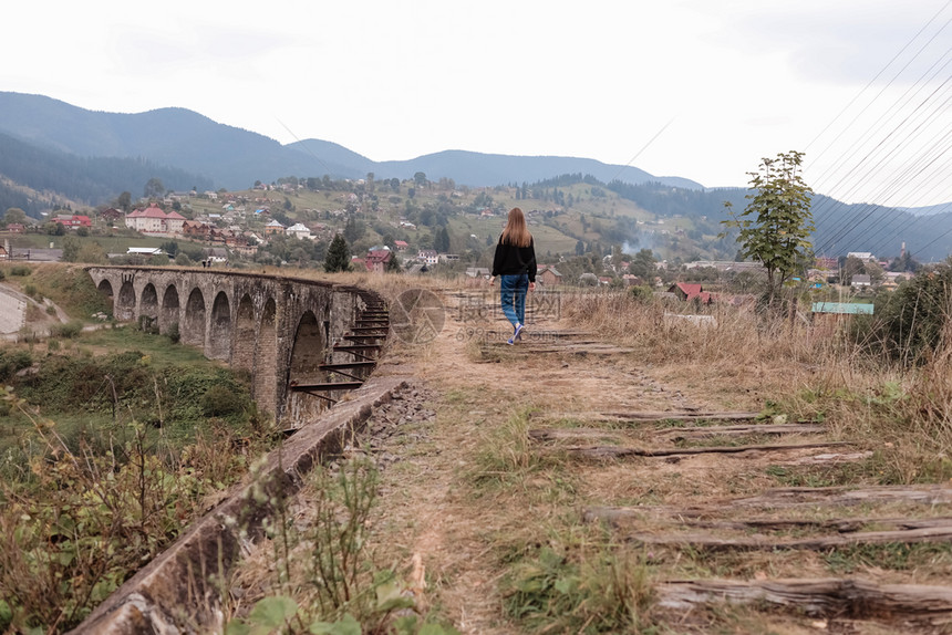 旅游少女在这条管道上走旧铁路在vorhta山村的老铁路道上走图片