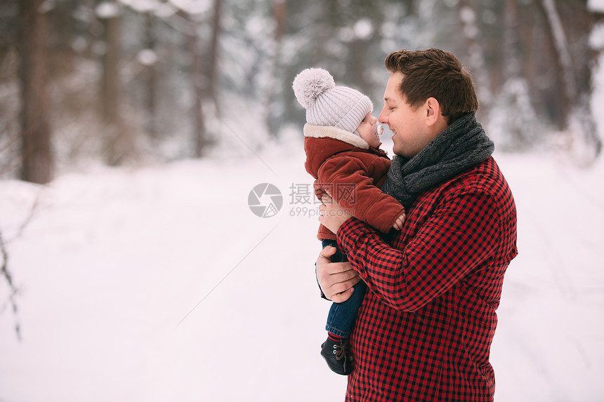 爸爸和宝宝在冬季森林里玩乐图片