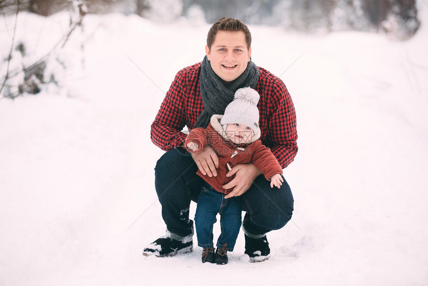 爸爸和儿子在冬季森林里玩乐图片