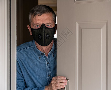 身戴防流感冠状和问候访客防护呼吸面具的担心男子背景图片