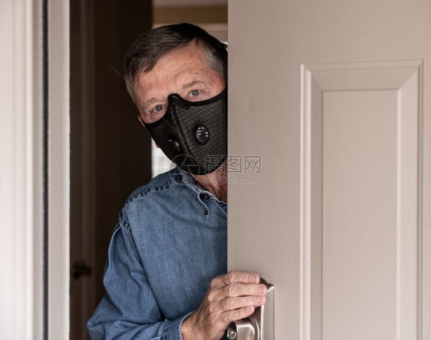 身戴防流感冠状和问候访客防护呼吸面具的担心男子图片