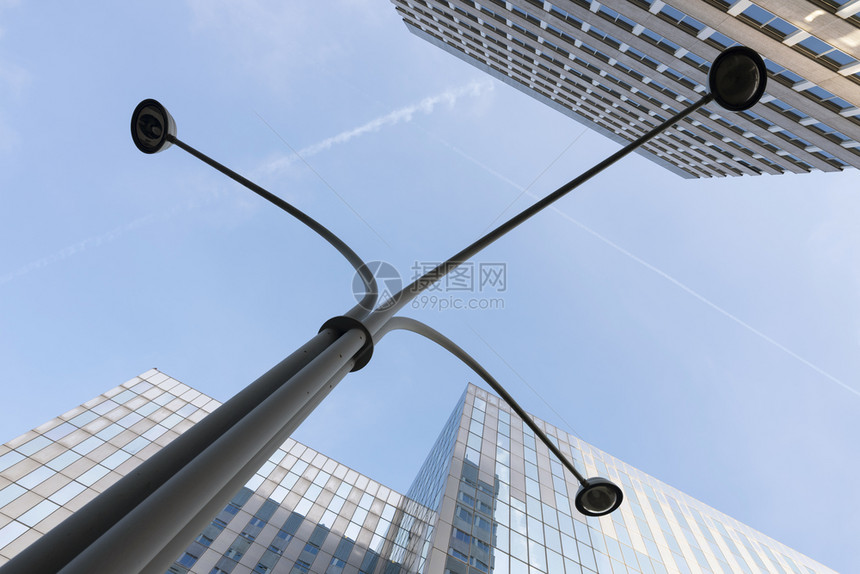 蓝色天空和云下有玻璃钢铁和灯柱的现代办公结构图片