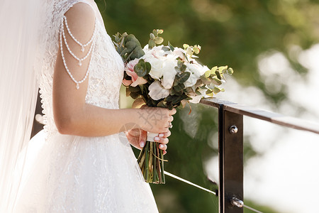 新娘拿着一束粉红花和白新娘拿着一束粉红花和白背景图片