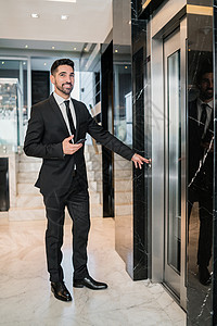商人站在酒店大厅的电梯前图片