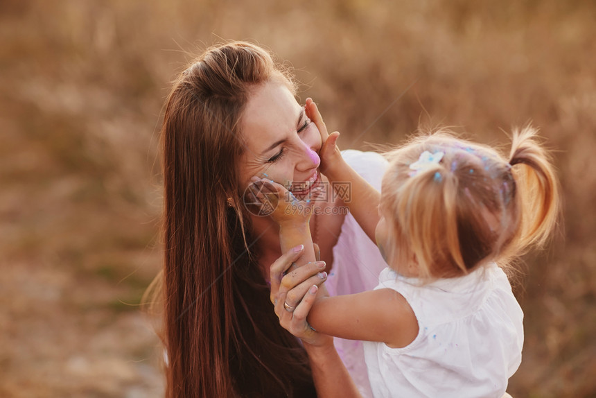霍利节乐趣和人的概念母亲和可爱的小女儿在白色背景上一起玩彩色粉末两个在霍利节玩彩色图片