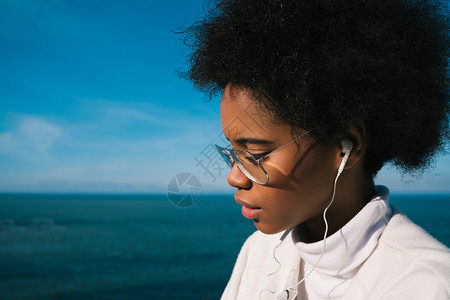 拉丁女人在海边聆听音乐图片