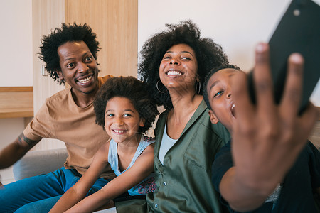 非洲的美洲的fmily在家中使用自拍和手机的肖像家庭和生活方式概念图片