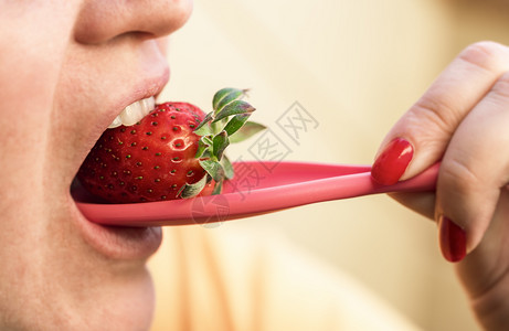女人用勺子吃草莓近乎女人的嘴咬草莓新鲜的夏季水果美味的健康甜点的果子图片