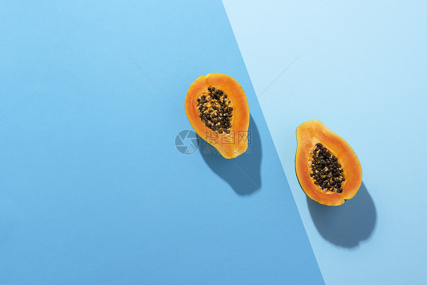 熟的木瓜水果在蓝色的杜奥通底被切成两半图片