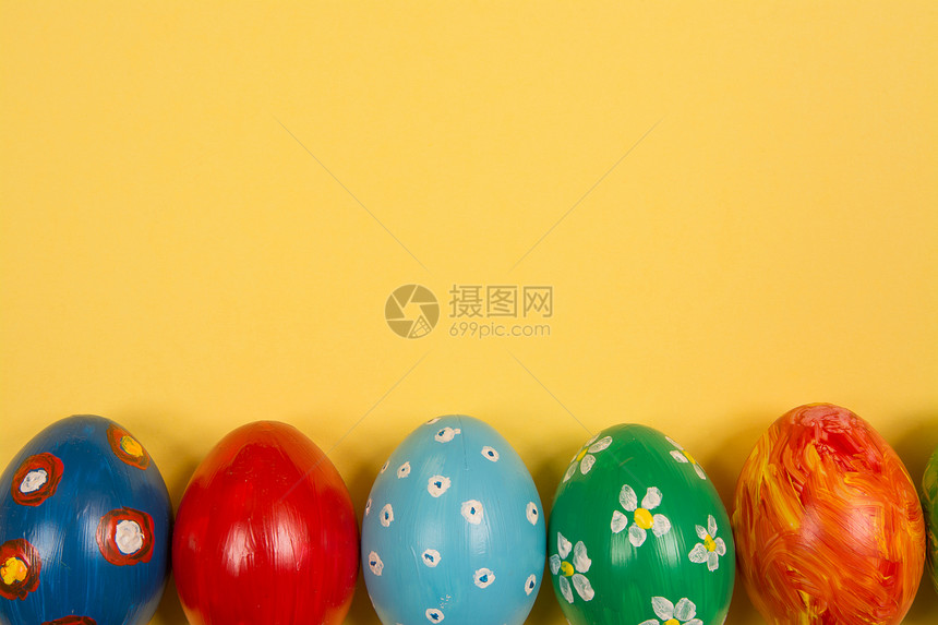 亮黄色背景上带艺术绘画的鸡蛋图片