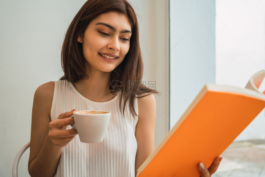 年轻女性在咖啡店喝咖啡享受阅读图片