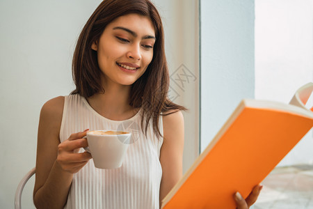 年轻女性在咖啡店喝咖啡享受阅读图片