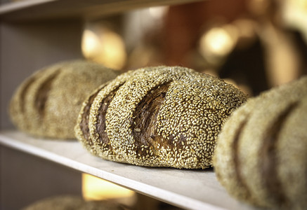 面包架上新鲜烤的芝麻面包店背景图片