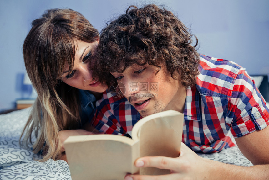 一对年轻夫妇起阅读躺在床上的书一对在床上看书的夫妇图片