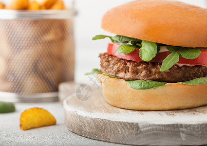 健康素食免费肉汉堡在圆环切肉板上蔬菜在浅色背景和土豆杂草上图片
