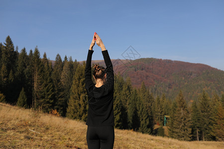 山顶上练瑜伽的少女图片