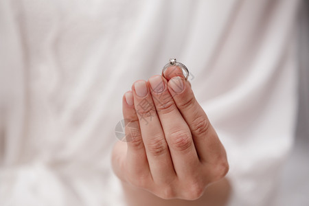 女手持白金和色钻石的婚戒奢侈昂贵的求婚戒指礼当天的新娘婚礼当天的新娘图片