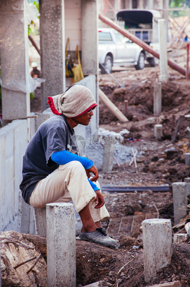 泰国工人坐在工地的石柱上图片