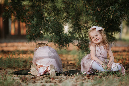 小可爱女孩在阳光明媚的春天树下玩得开心图片