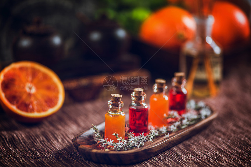 木板上装满红油和橙的瓶子新鲜柑橘水果橙子和石灰被切成两半图片