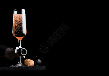 优雅的粉红玫瑰香槟装有软木塞铁丝笼和黑底大理石板上的瓶子图片