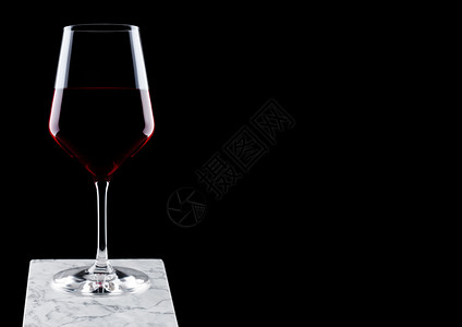 白大理石板上的红葡萄酒黑色背景背景图片
