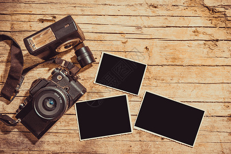 旧胶片相机和木制桌上两个空白照片框带有复制空间的最高视图图片
