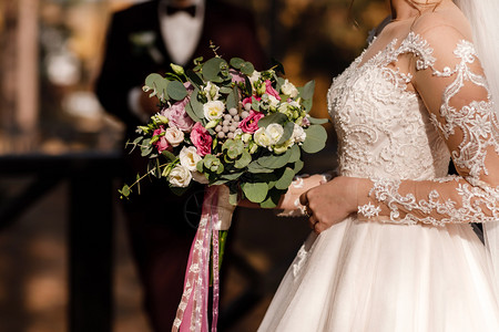 新娘拿着粉红色和白色的花束图片