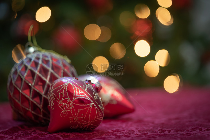 精细的圣诞装饰品躺在桌子上明亮的树前图片