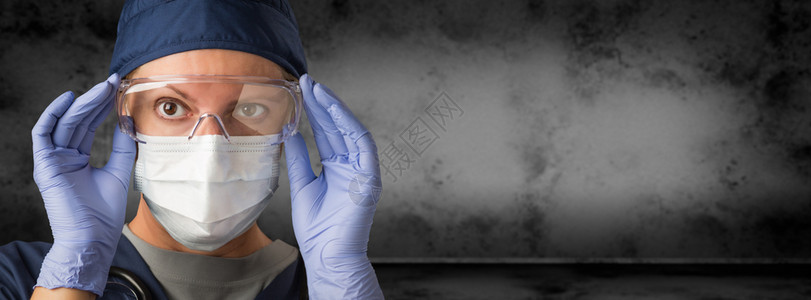 身戴护目镜外科手套和面罩的女医生或护士图片