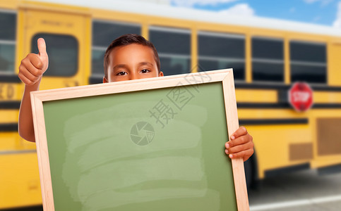 在学校巴士附近带着空白的黑板人小男孩图片