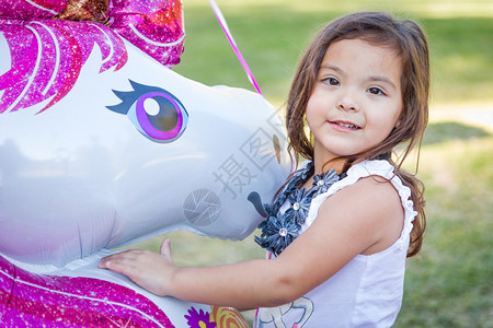 可爱的青春混血儿女婴抱着神秘气球在户外图片