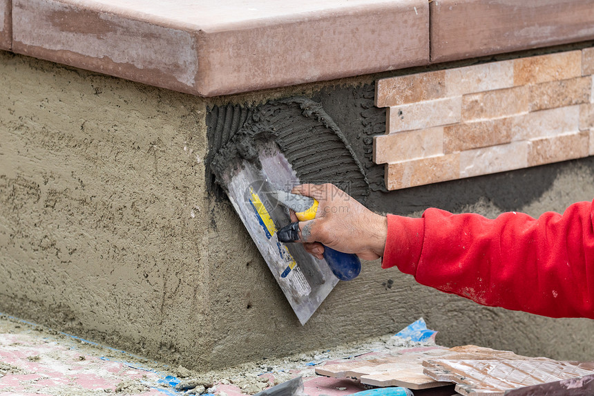 工人们在建筑地安装墙壁瓷砖水泥加土和瓷砖图片