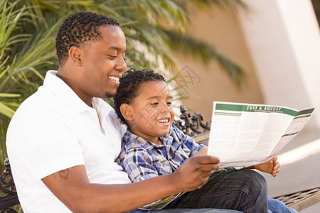 快乐的非裔美国父亲和混血儿在外边看公园小册子很愉快图片