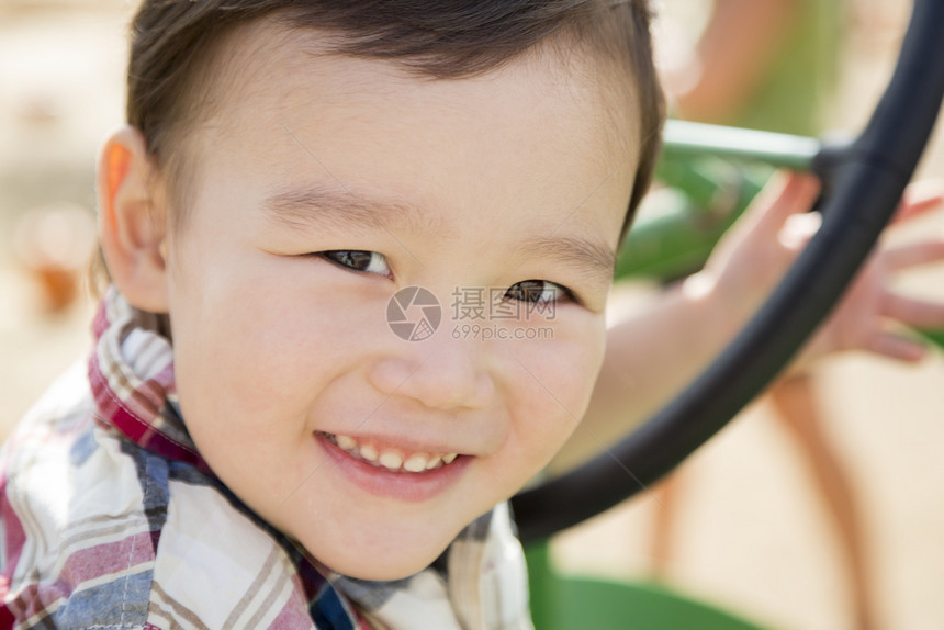 可爱的混合种族男孩玩拖拉机在南瓜区图片