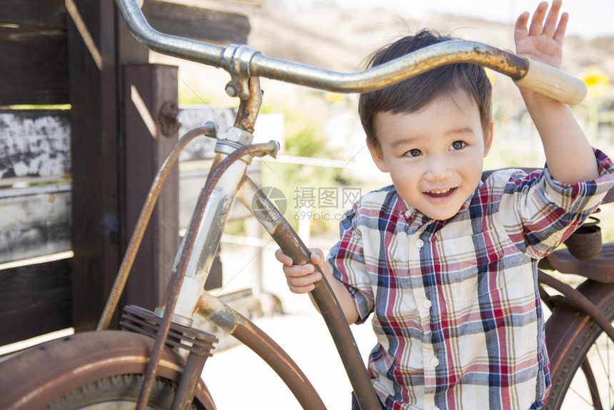可爱的混合种族年轻男孩在自行车上玩得开心图片
