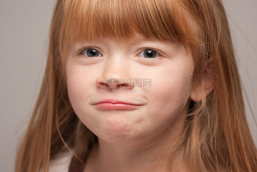 一个灰色背景的可爱红发女孩肖像图片