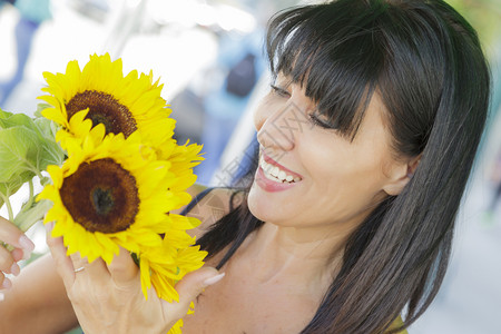 美丽的意大利女人在街头市场看向日葵图片
