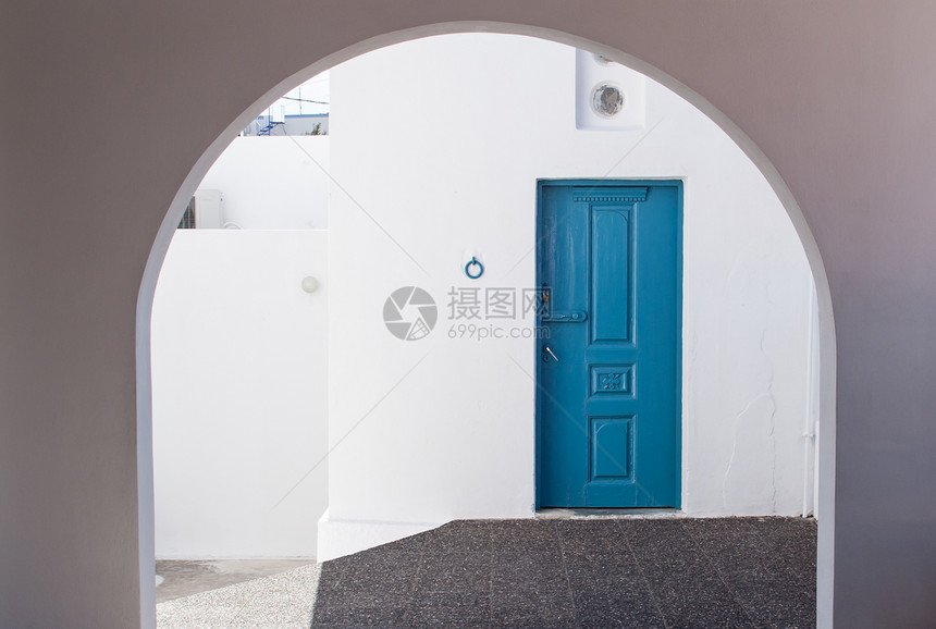 美丽的白色建筑和蓝门入口在圣塔里尼裂缝图片