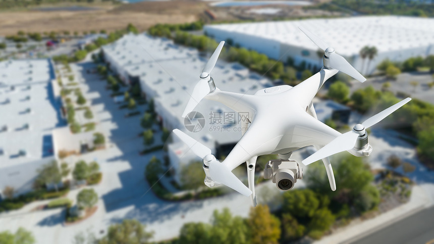 无人机在公司工业大楼附近的空中飞行图片