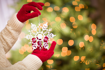 妇女穿着季节红手套带着白雪花圣诞节装饰品图片