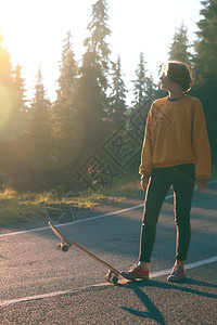 夏天的公路旅行美丽的风景和山路色女孩骑着滑板在横贯阿尔卑斯山罗马尼亚图片