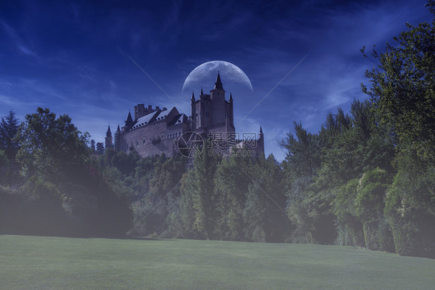 西班牙塞哥维亚的古老中世纪宫殿夜幕在蓝色时段与月亮拍攝图片