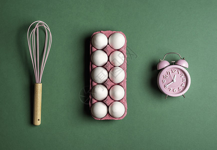 粉红闹钟胡须和鸡蛋卡通绿色背景时间概念图片