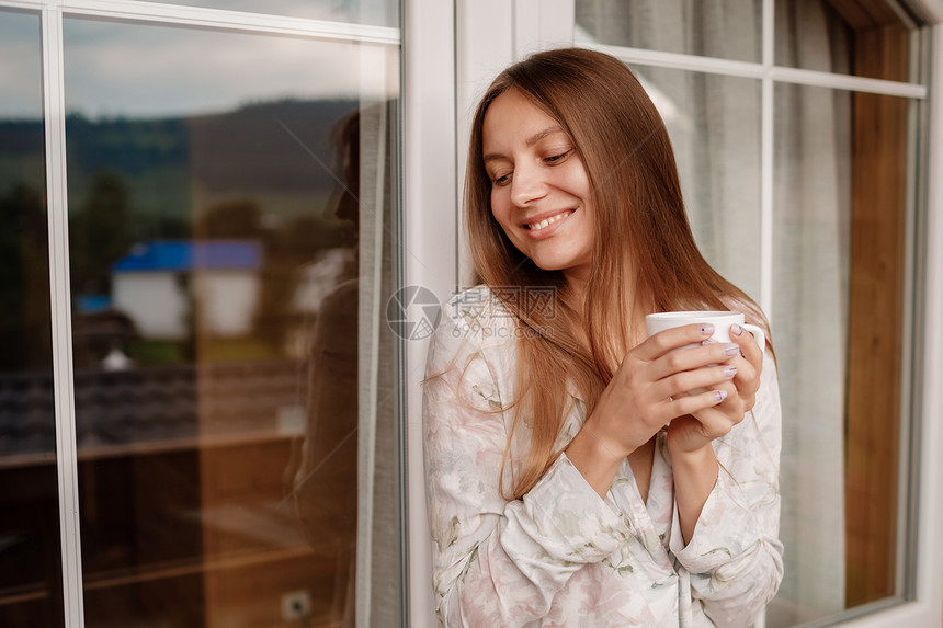 女孩在阳台喝咖啡的肖像图片