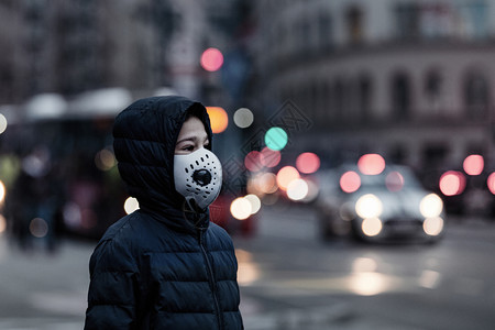 城市中受污染的空气佩戴防护面具图片